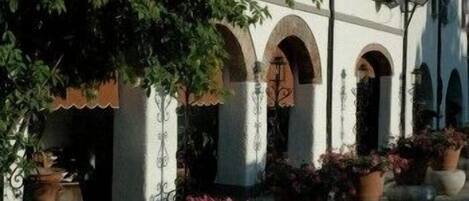 A building with arched doorways and potted plants.