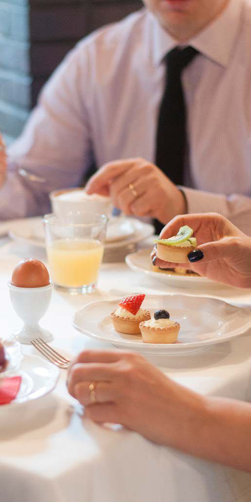 A dining table with plates of food, a glass of orange juice, and a cup.