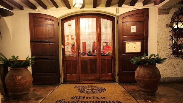 A wooden door with a glass panel and a doormat reading "Minca Gastronomia ARNALDO". - Hotel Arnaldo Aquila d'Oro (Rubiera)