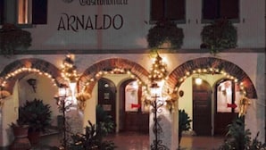 A building with the sign 'Clinica Gastronomica ARNALDO' and a covered outdoor area with arches and lights. - Hotel Arnaldo Aquila d'Oro (Rubiera)