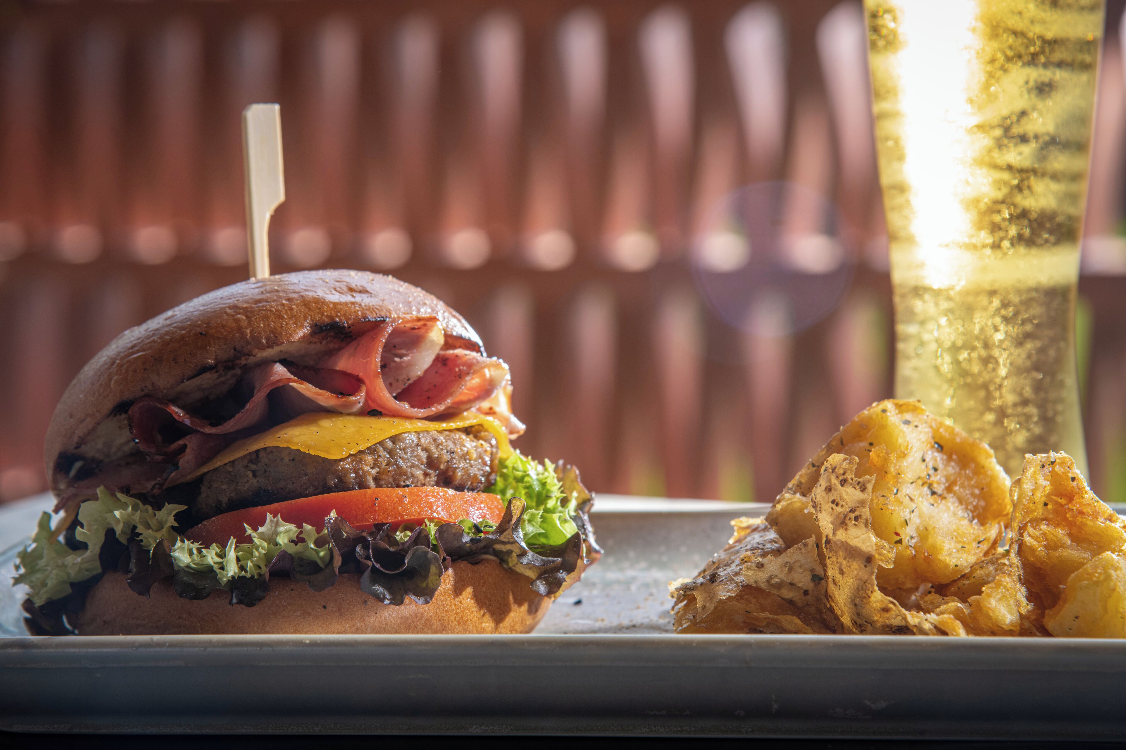 Una hamburguesa con diferentes ingredientes y una porción de papas fritas.