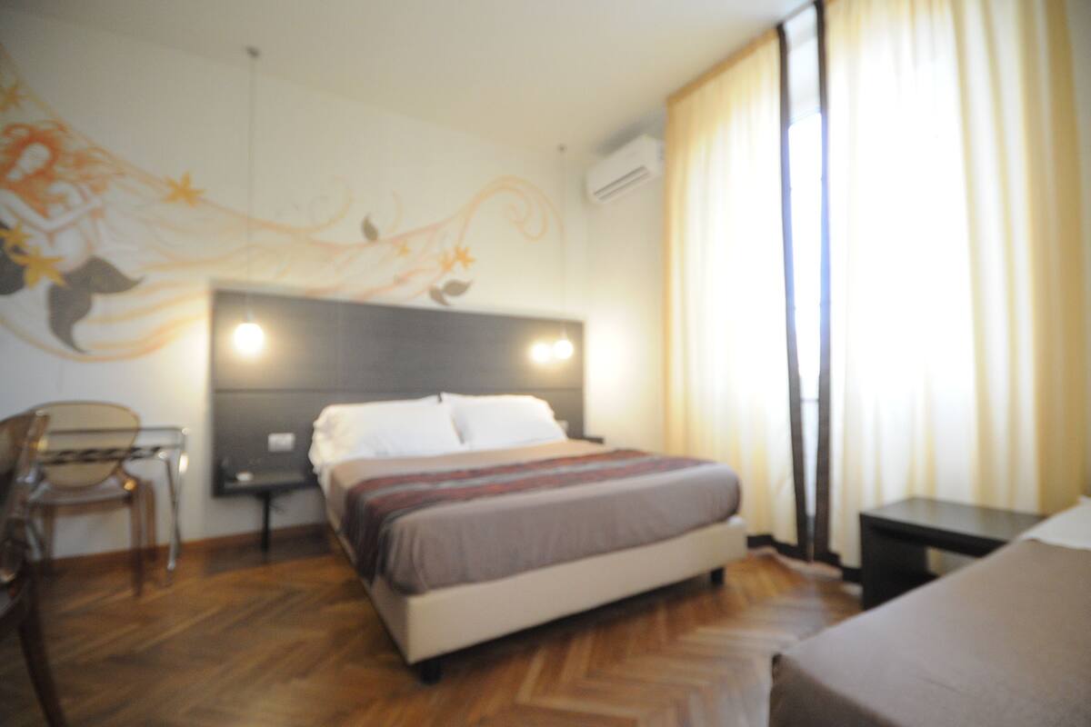 Une chambre d’hôtel avec un lit, un bureau et une chaise.