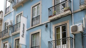 Un edificio con varios balcones, un letrero que dice 