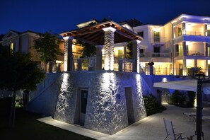 A multi-story house with a stone facade, a covered outdoor area, and a staircase leading to the upper levels.