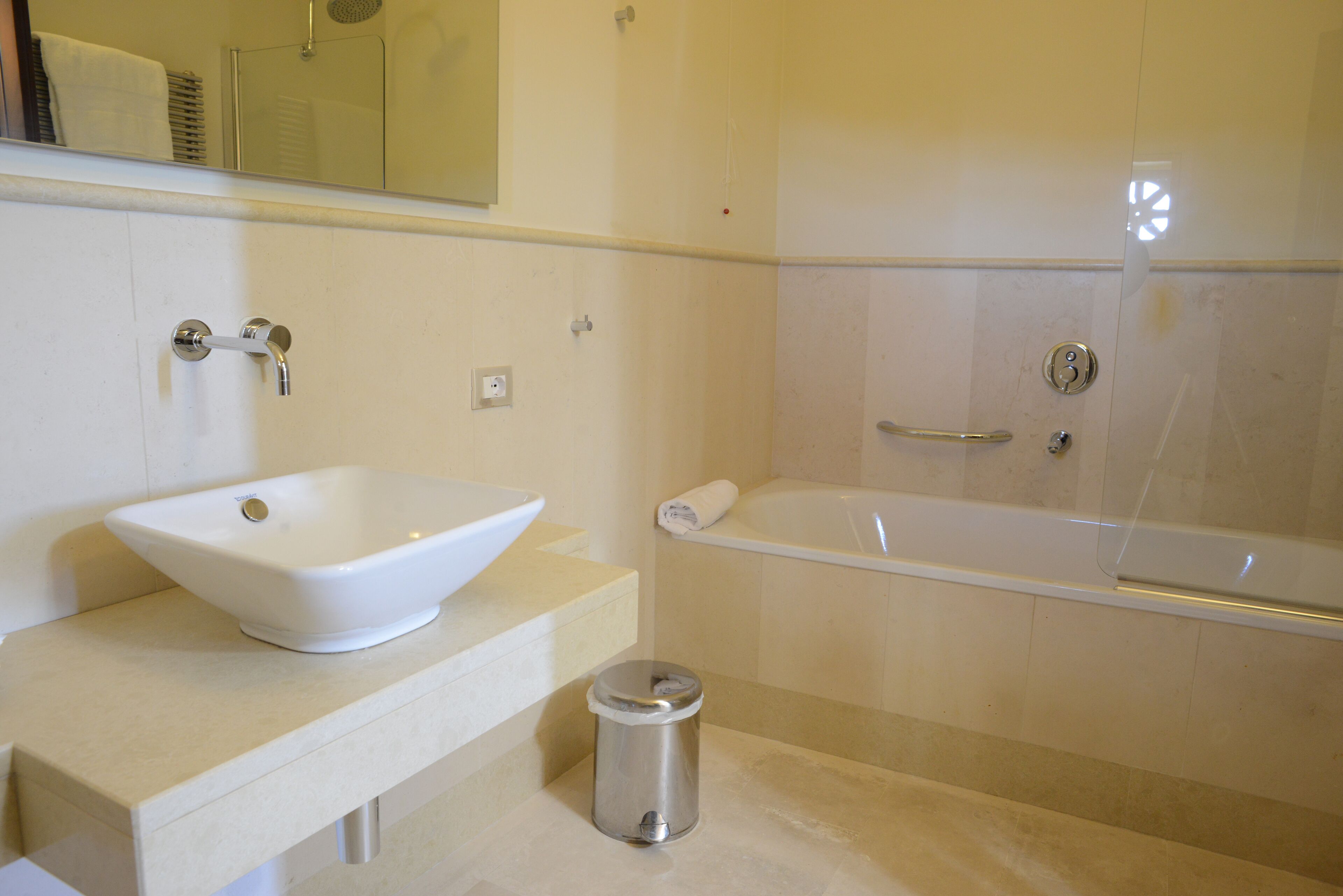 Un baño con lavamanos, espejo y bañera.