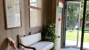 A stone-floored lobby with a wooden bench and a small table with brochures. - Castello La Rocchetta (Sandigliano)