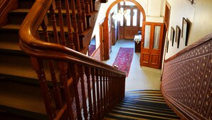 Un escalier en bois, doté d’une rampe, mène à un palier.