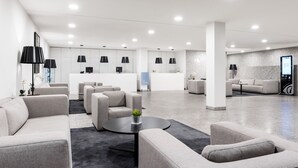 A modern lobby with sofas, a reception desk, and pendant lighting. - Eurostars Mar de Vigo (Vigo)