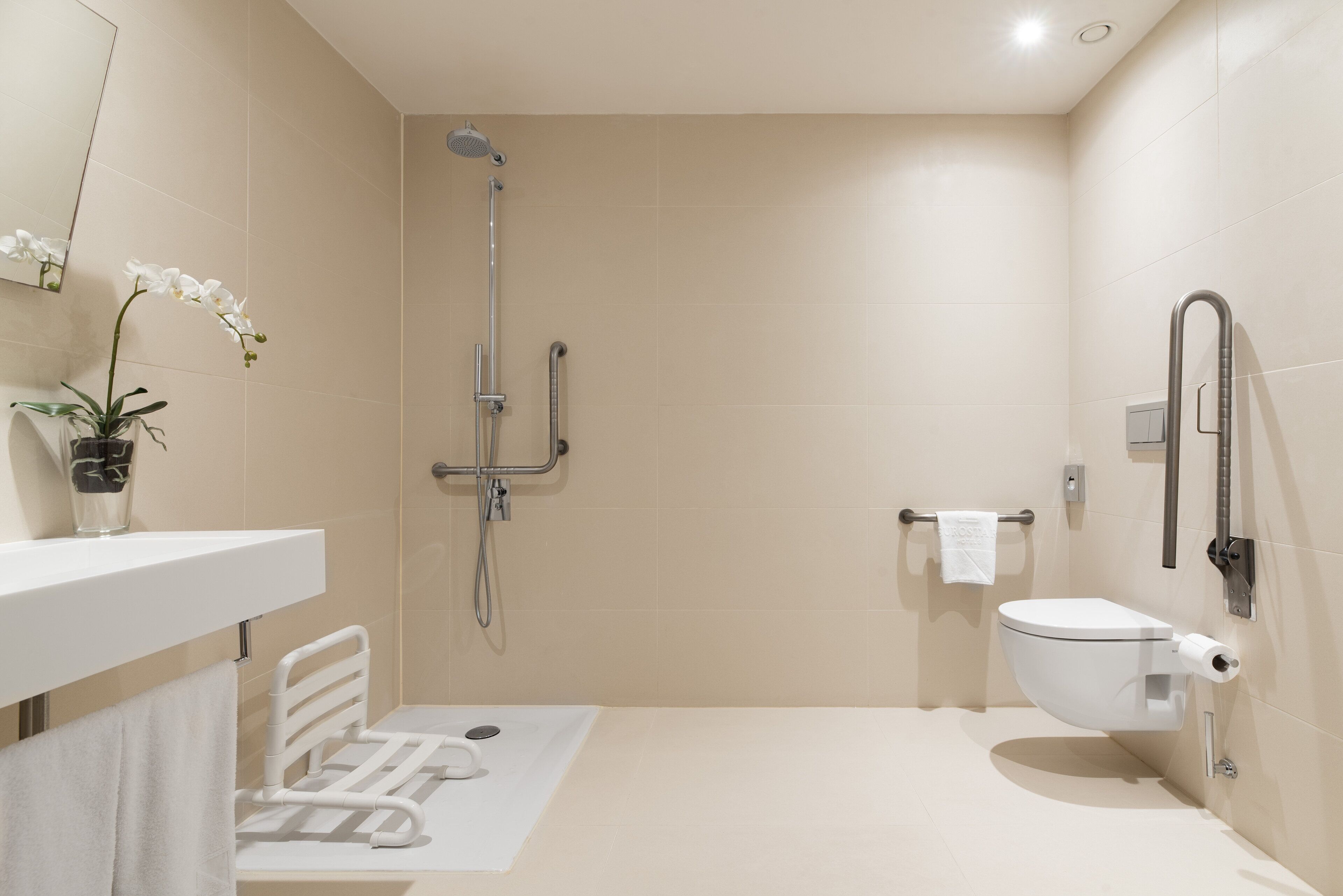 A modern bathroom with a shower, toilet, and a towel rack.