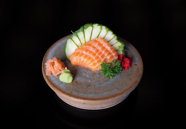 A bowl of food with salmon, cucumber, and garnishes. - Tauá Resort Caeté (Caete)
