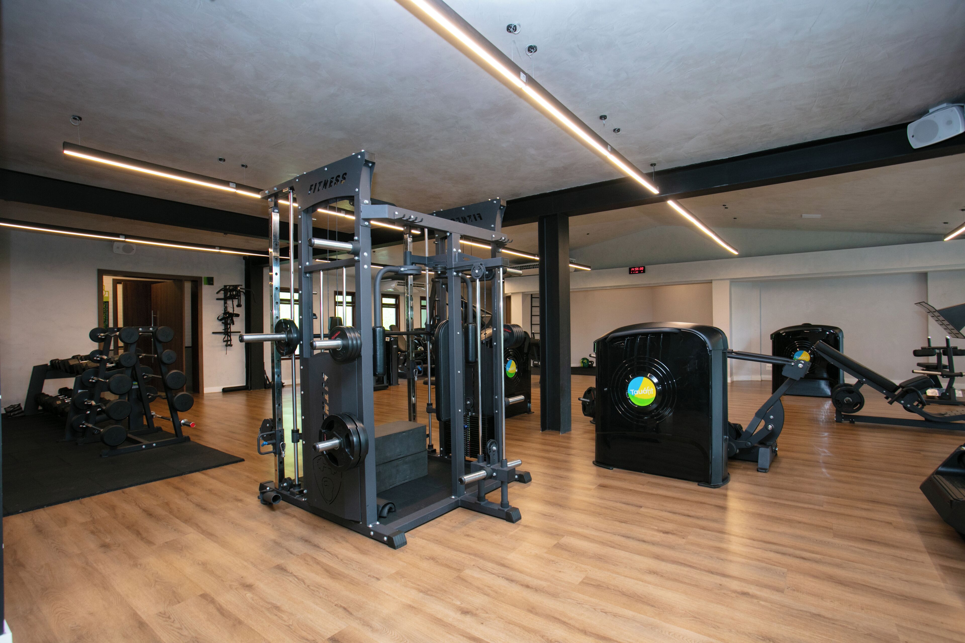 A gym with various exercise equipment, including a squat rack and a bench press.