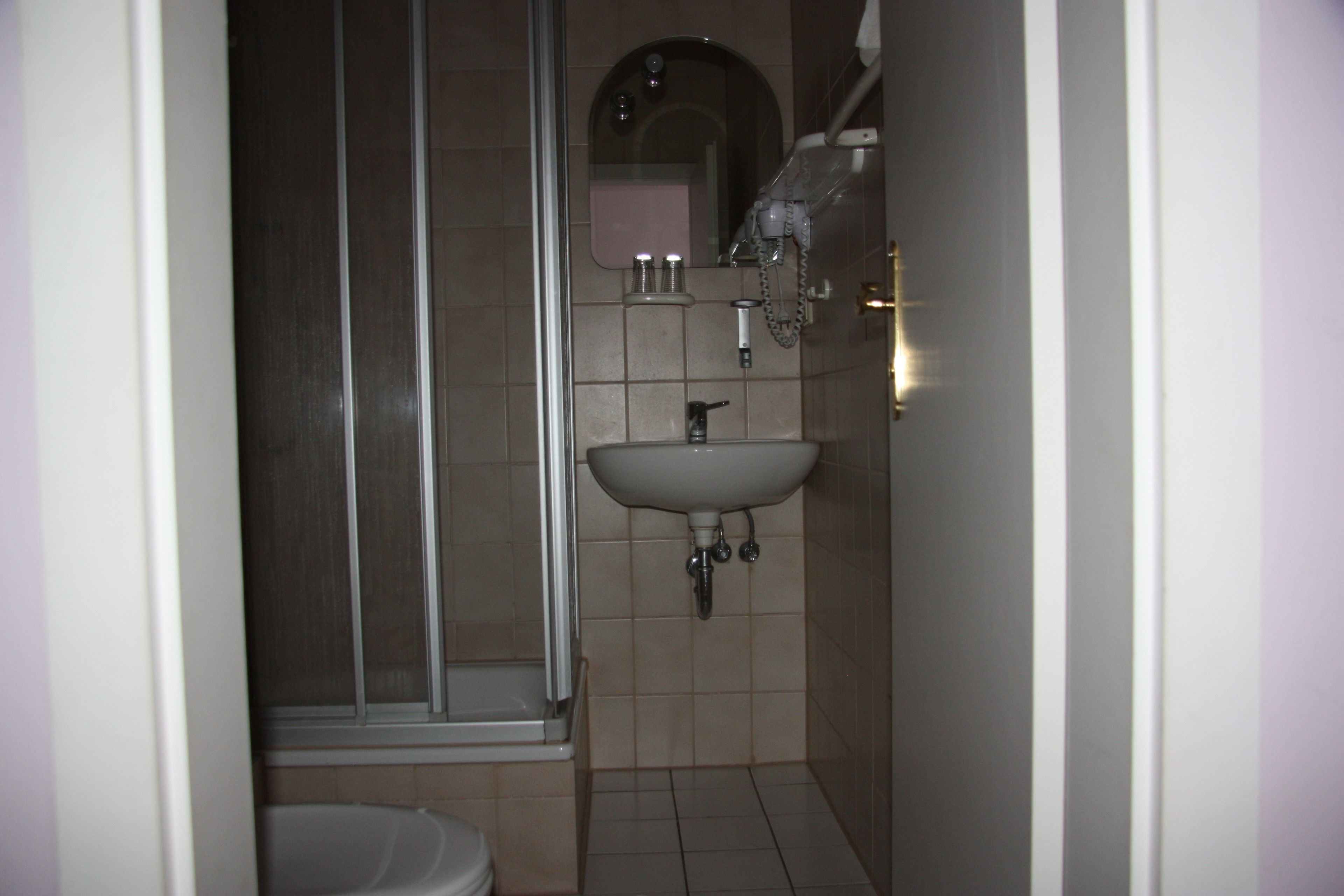 Un baño con ducha, lavabo e inodoro.