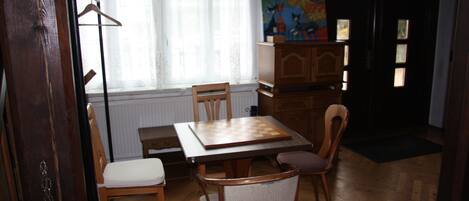 Un comedor con una mesa de madera, sillas y un armario.