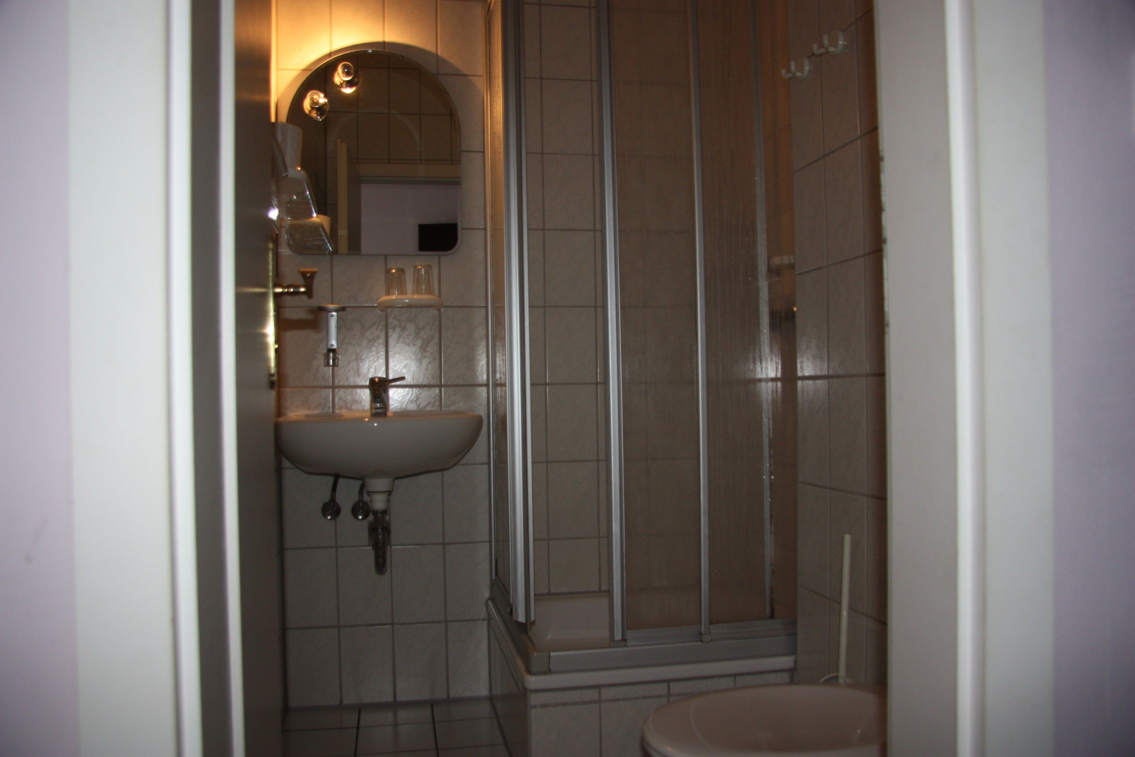 Une salle de bain équipée d’un lavabo, d’un miroir et d’une cabine de douche.