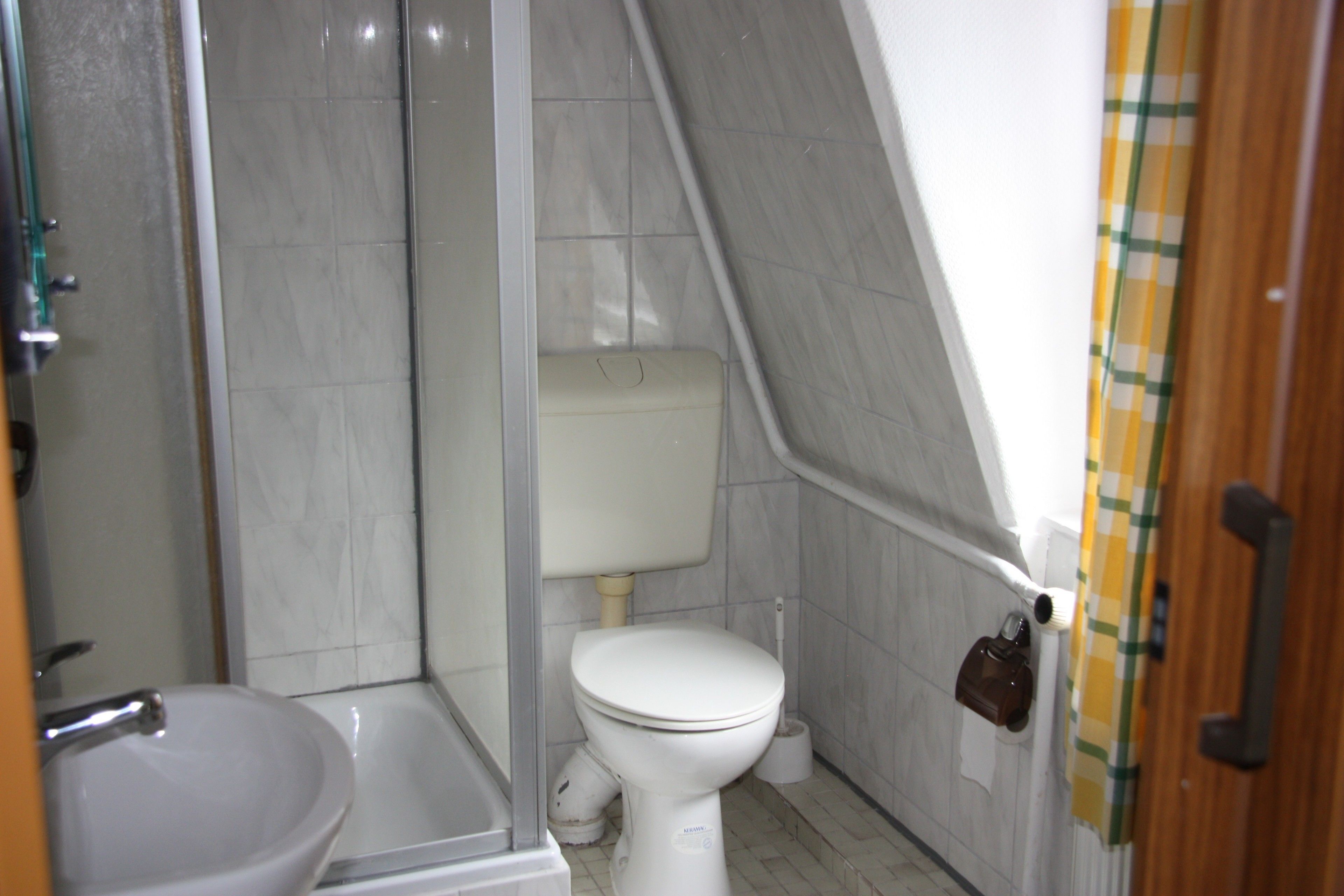 A bathroom with a toilet, sink, and shower.