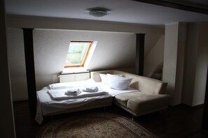 A bedroom with a bed, a sofa, a window, and a radiator. - Hotel - Zum goldenen Stern (Unterspreewald)