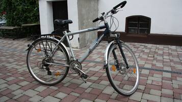 A stationary bicycle parked on a brick pavement.