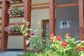 A wooden pergola with hanging flower baskets and a sign for Hotel Natura. - Hotel Natura (Castel di Sangro)