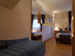 A hotel room with a bed, a desk, and a mirror. - Hotel Natura (Castel di Sangro)