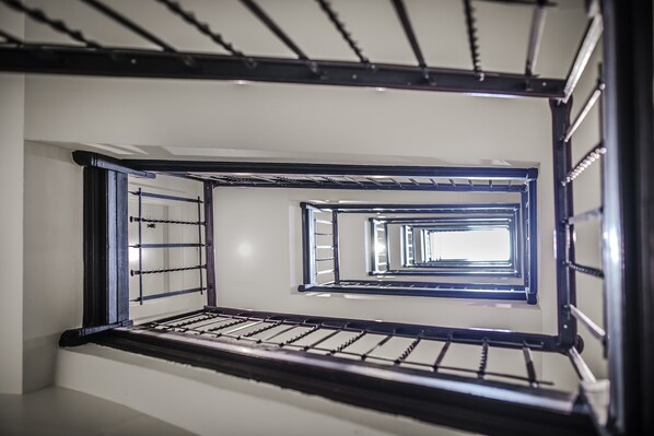 Stairs lead upwards through a simple, white-walled space.