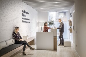 Welcome to our reception area, featuring a central desk and comfortable seating for guests.