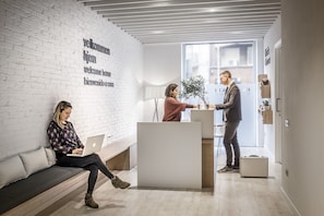 Welcome to our reception area, featuring a central desk and comfortable seating for guests.