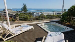 A deck with two sun loungers and a hot tub overlooking the ocean. - BlaauwVillage Boutique Guest House (Cape Town)