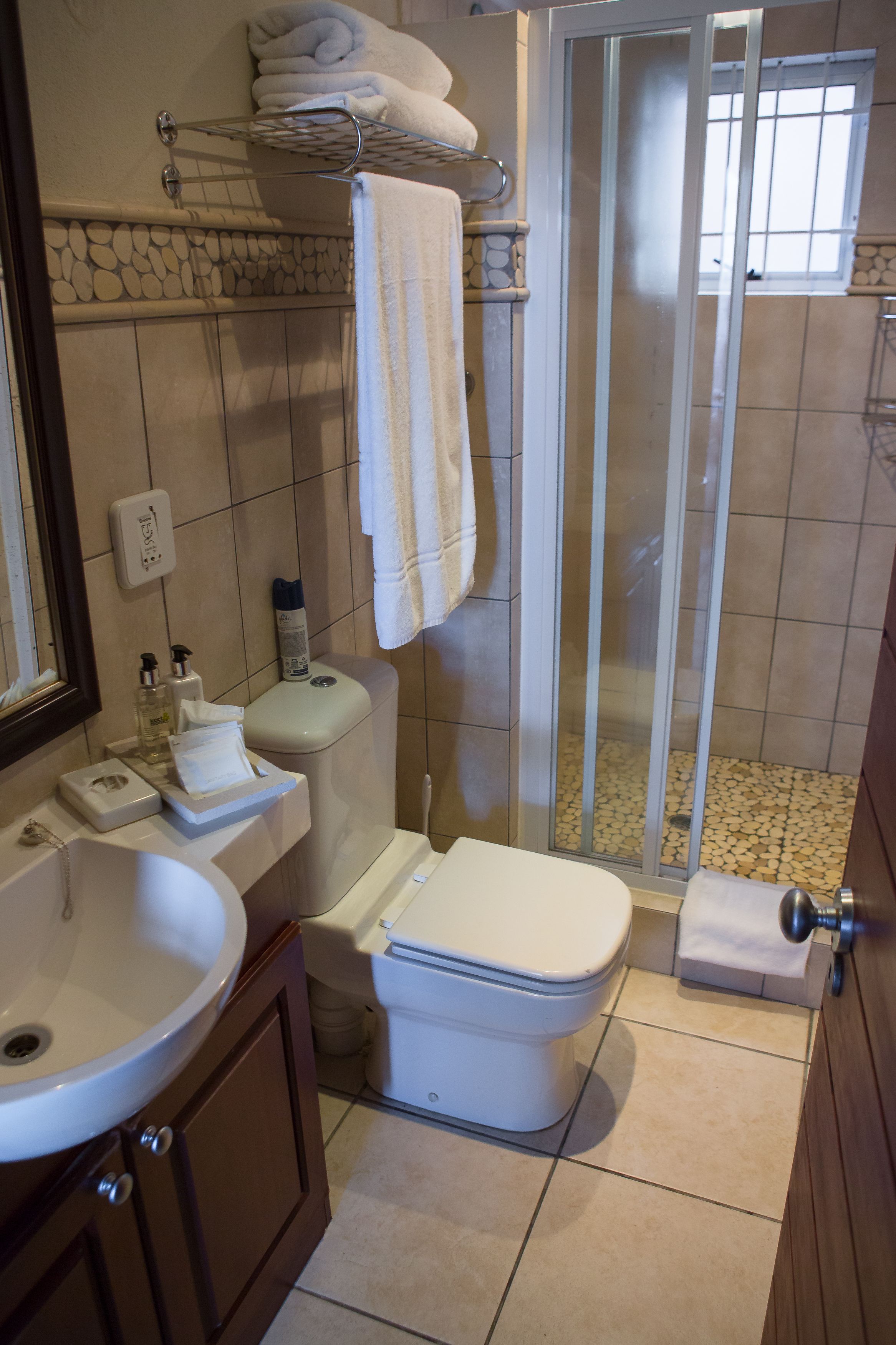 A bathroom with a toilet, sink, and shower area.