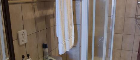 A bathroom with a toilet, sink, and shower area.