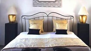 A bedroom with a bed, two bedside tables, and a framed picture on the wall. - Hotel Palacio Blanco (Velez-Malaga)