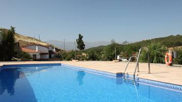 Una piscina al aire libre, tumbonas