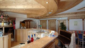 A bar area with wooden ceiling, bar counter, and seating. - Residence Pez Gajard (Primiero San Martino di Castrozza)