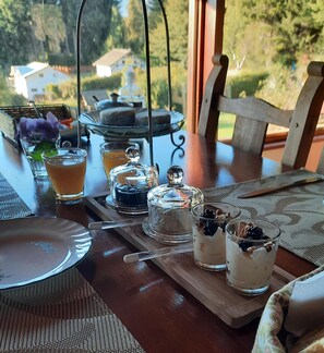A dining table with a tea set, glasses, and a tray with food items. - Le Bouquet Apart Hotel (Bariloche)