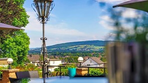 A table with a view of a village and hills in the background. - Altes Zollhaus (Rinteln)