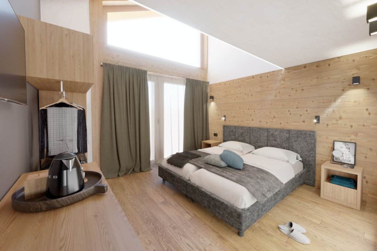 Un dormitorio moderno con una cama grande, paredes de madera, un perchero, una mesita de noche y un estante pequeño.
