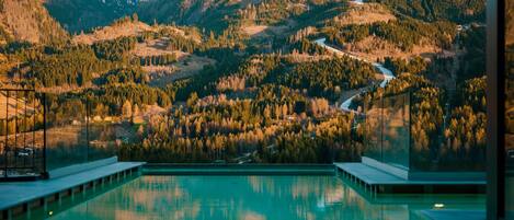 Alberca techada, alberca al aire libre y camastros