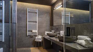 Un bagno moderno con un ampio specchio, un lavabo in pietra e un porta asciugamani.