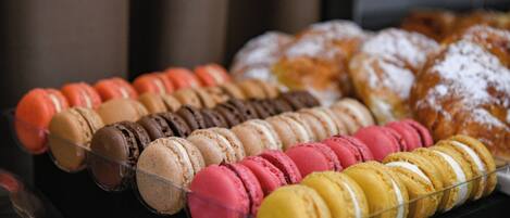 Una exhibición de pasteles variados, incluyendo macarons y donas.