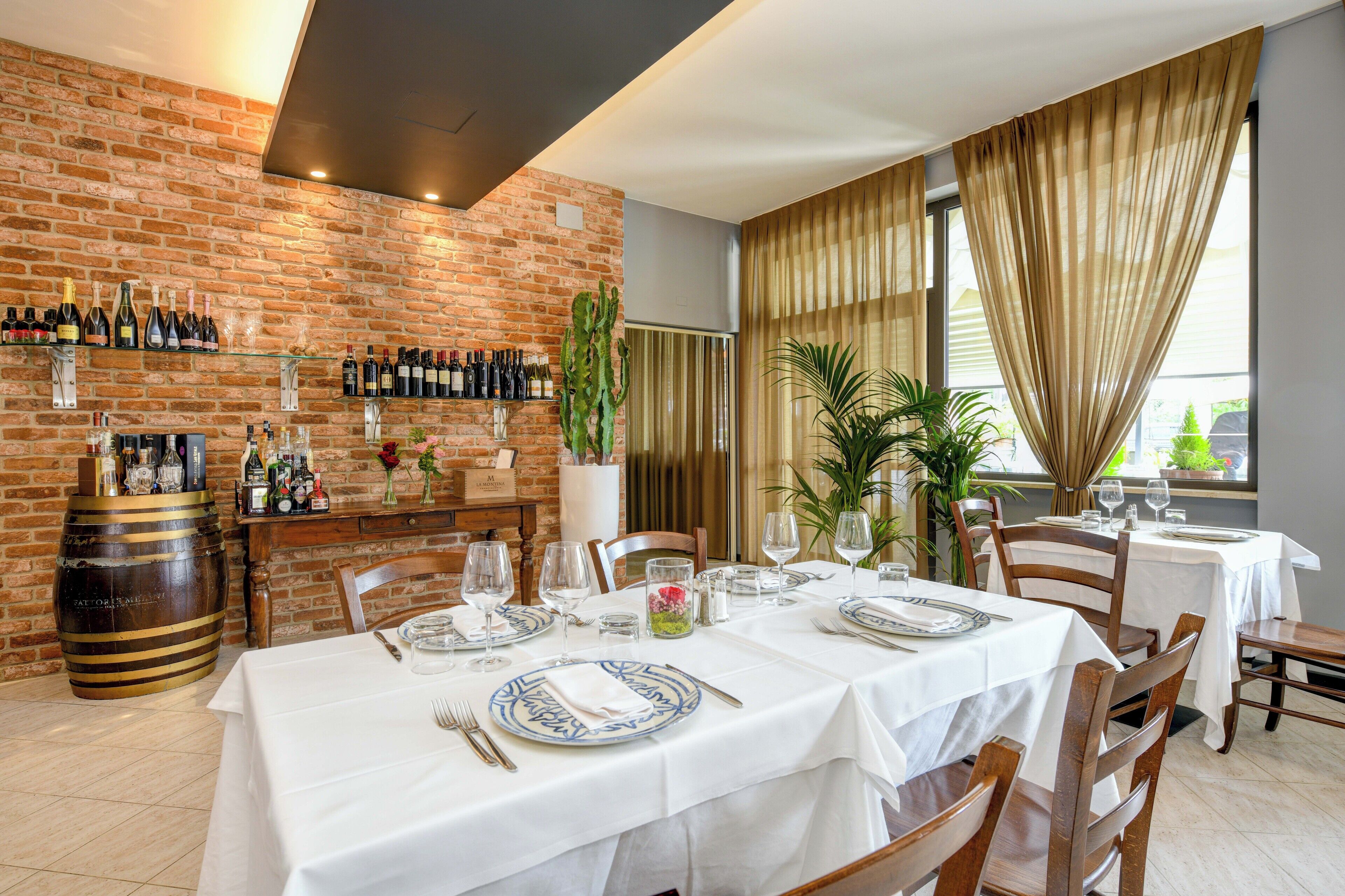 A restaurant with brick walls, a wine rack, and a table set for dining.