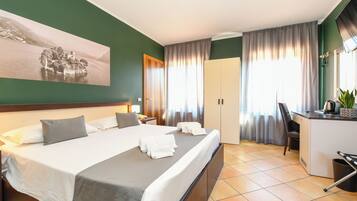 Ein Hotelzimmer mit einem großen Bett, einem Schreibtisch und Blick auf einen See.