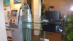 A reception area with a glass partition, a reception desk, a computer, and a poster on the wall. - Greentree Inn Shanghai Zhangjiang (Shanghai)