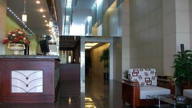A lobby with a reception desk, a seating area with patterned cushions, and a hallway leading to other parts of the building. - Greentree Inn Shanghai Zhangjiang (Shanghai)