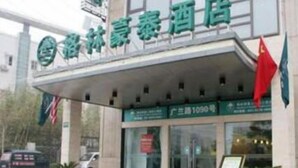 A hotel entrance with a green sign, a red flag, and a signboard. - Greentree Inn Shanghai Zhangjiang (Shanghai)