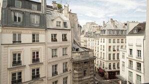 Una hilera de edificios históricos de estilo europeo, con varios pisos, detalles arquitectónicos clásicos y diseños de ventanas uniformes.