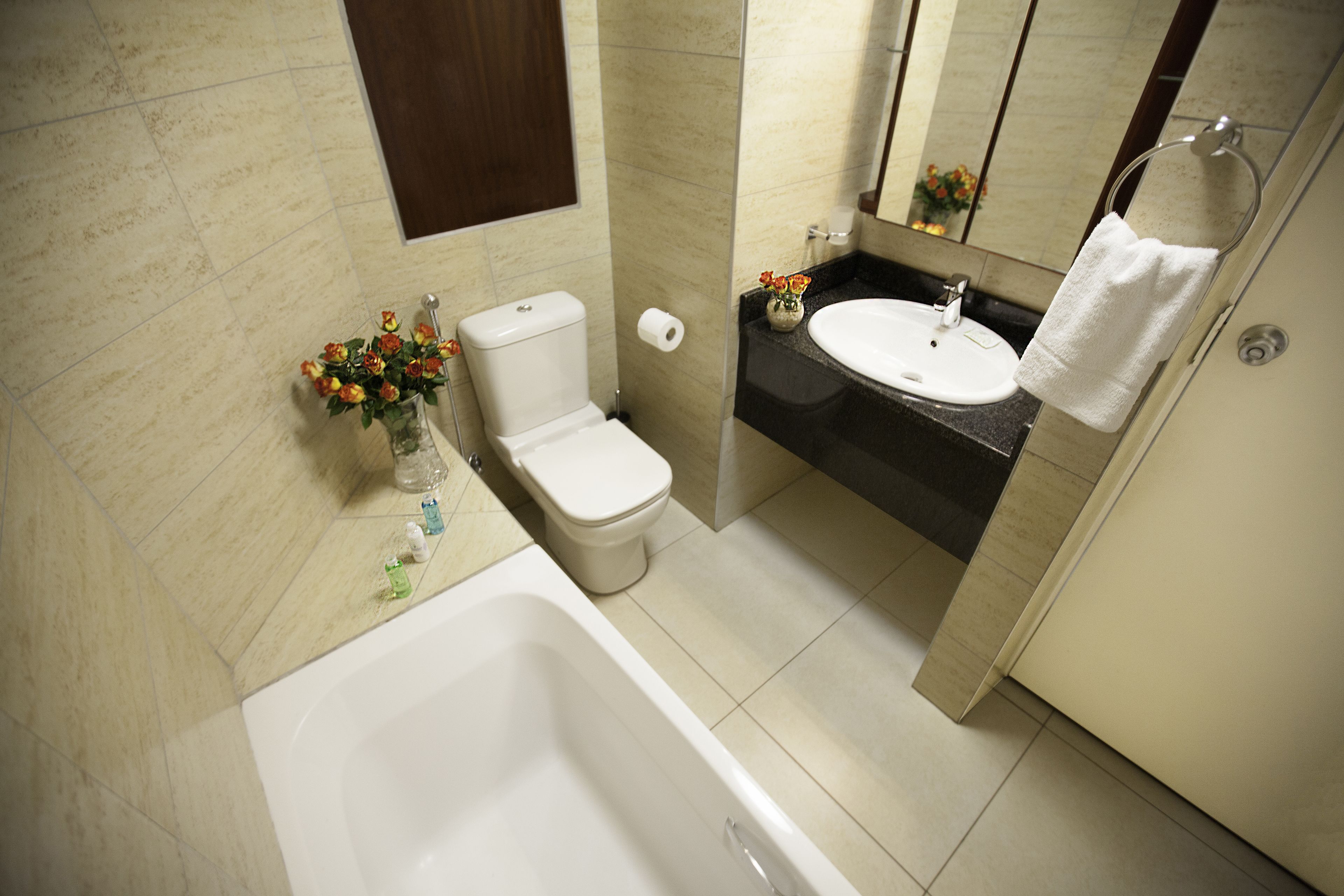 Ein Badezimmer mit Badewanne, Toilette, Waschbecken und Spiegel.