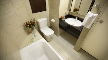 Ein Badezimmer mit Badewanne, Toilette, Waschbecken und Spiegel.