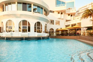 室外游泳池，池畔遮阳伞，日光浴躺椅