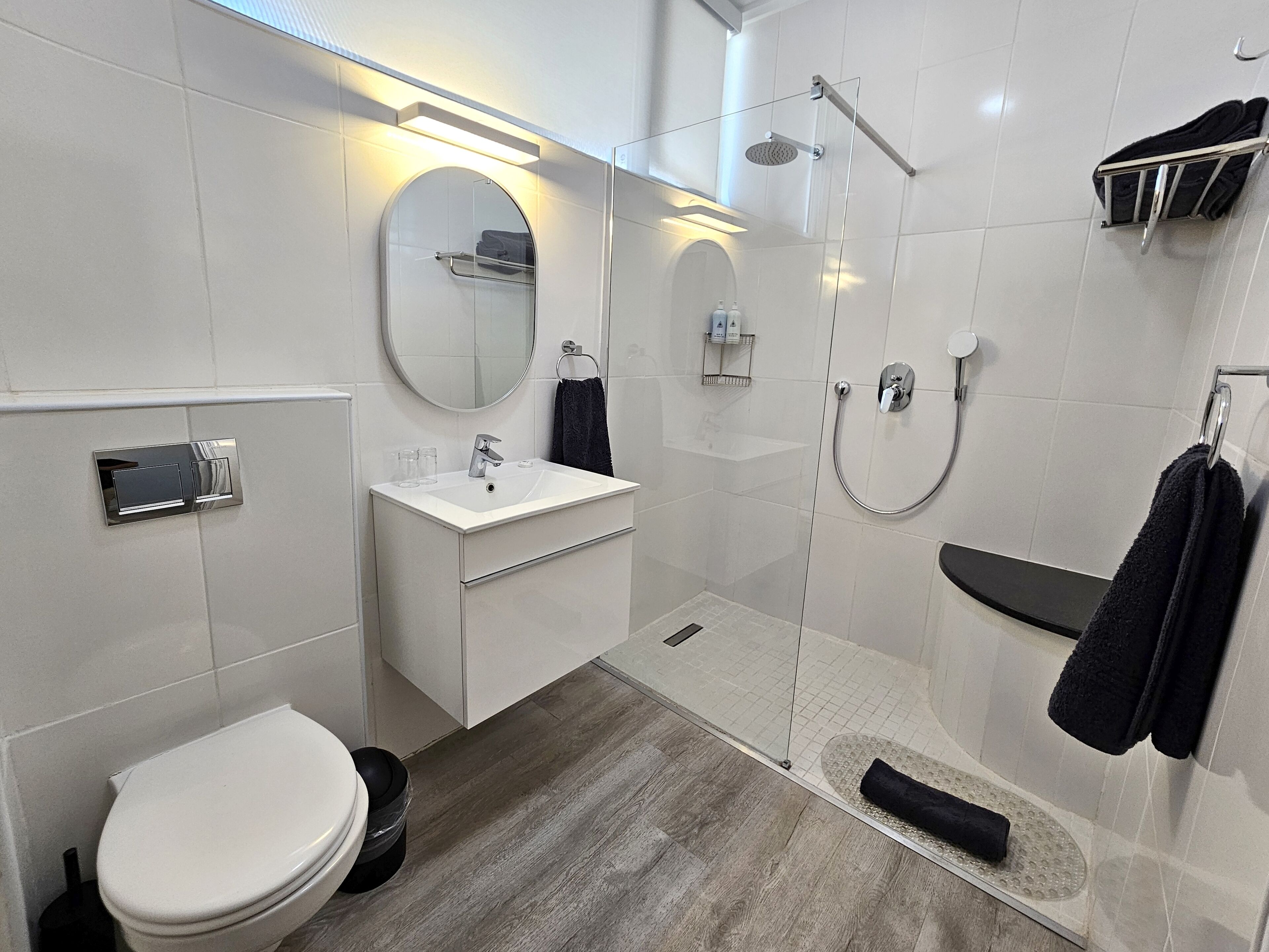 A modern bathroom with a toilet, sink, and shower.