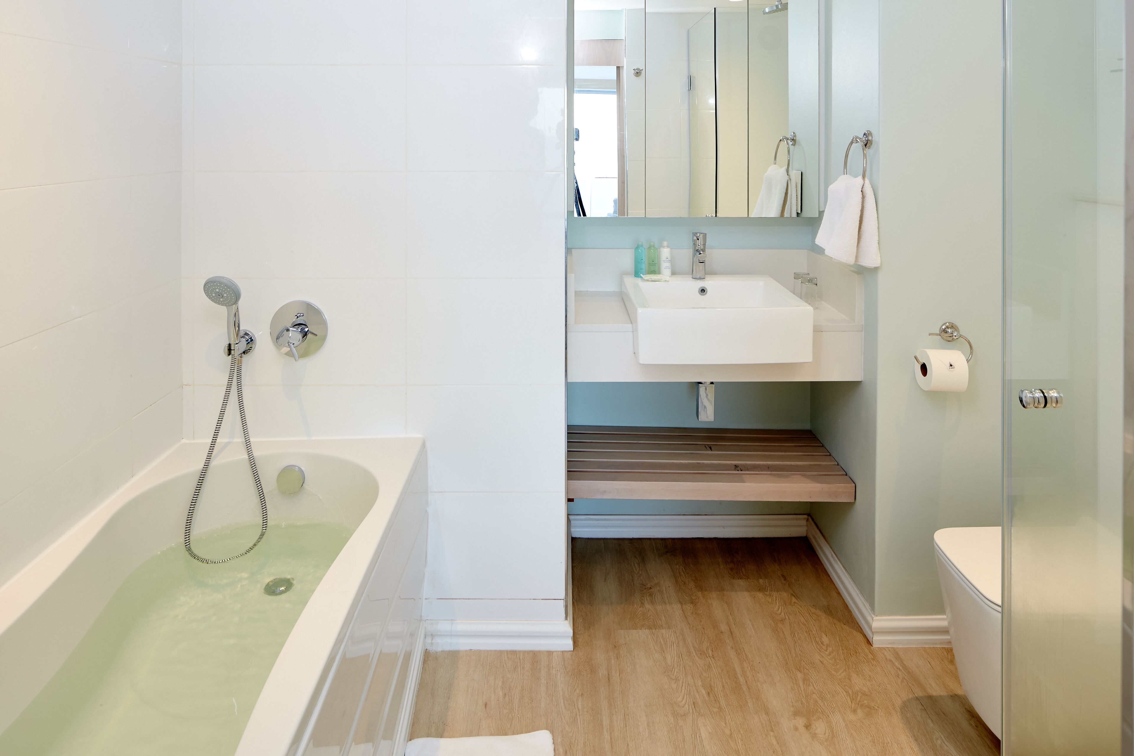 Un baño moderno con bañera, lavamanos e inodoro.