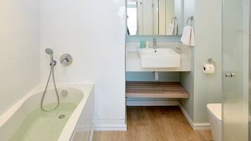 Un baño moderno con bañera, lavamanos e inodoro.
